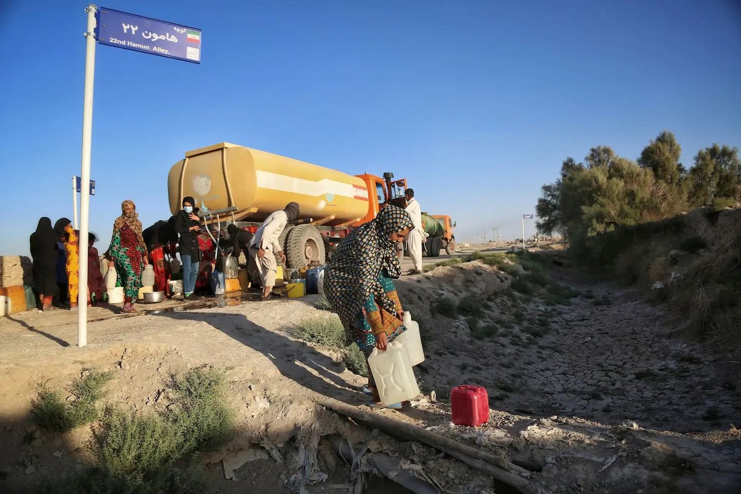 PHOTO: Cette image non datée, prise en mai 2023, montre des habitants allant chercher de l'eau dans un camion-citerne près du lac Hamun asséché. La province iranienne du Sistan-et-Baloutchistan est touchée par la sécheresse et des pénuries d'eau.